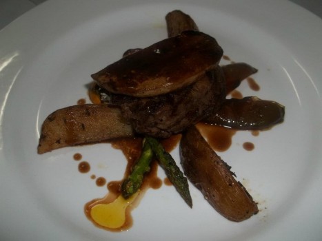 "Beef tenderloin Rossini style with tranche of pan seared duck liver, roasted potatoes,  grilled garlic vegetables and port wine jus"