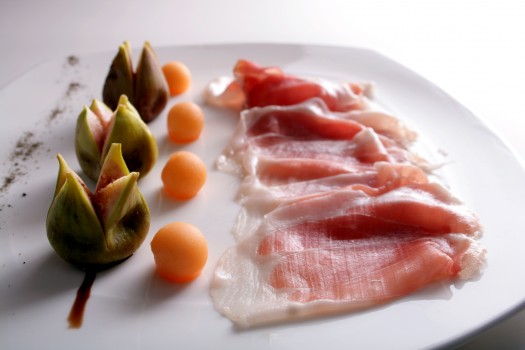 Platter of thinly sliced parma ham with figs and melon
