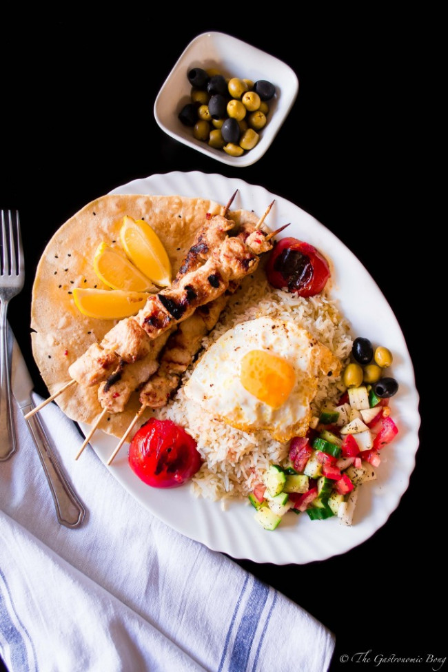 Persian Joojeh Kebab On A Bed Of Chelo And Fried Egg With Shirazi Salad
